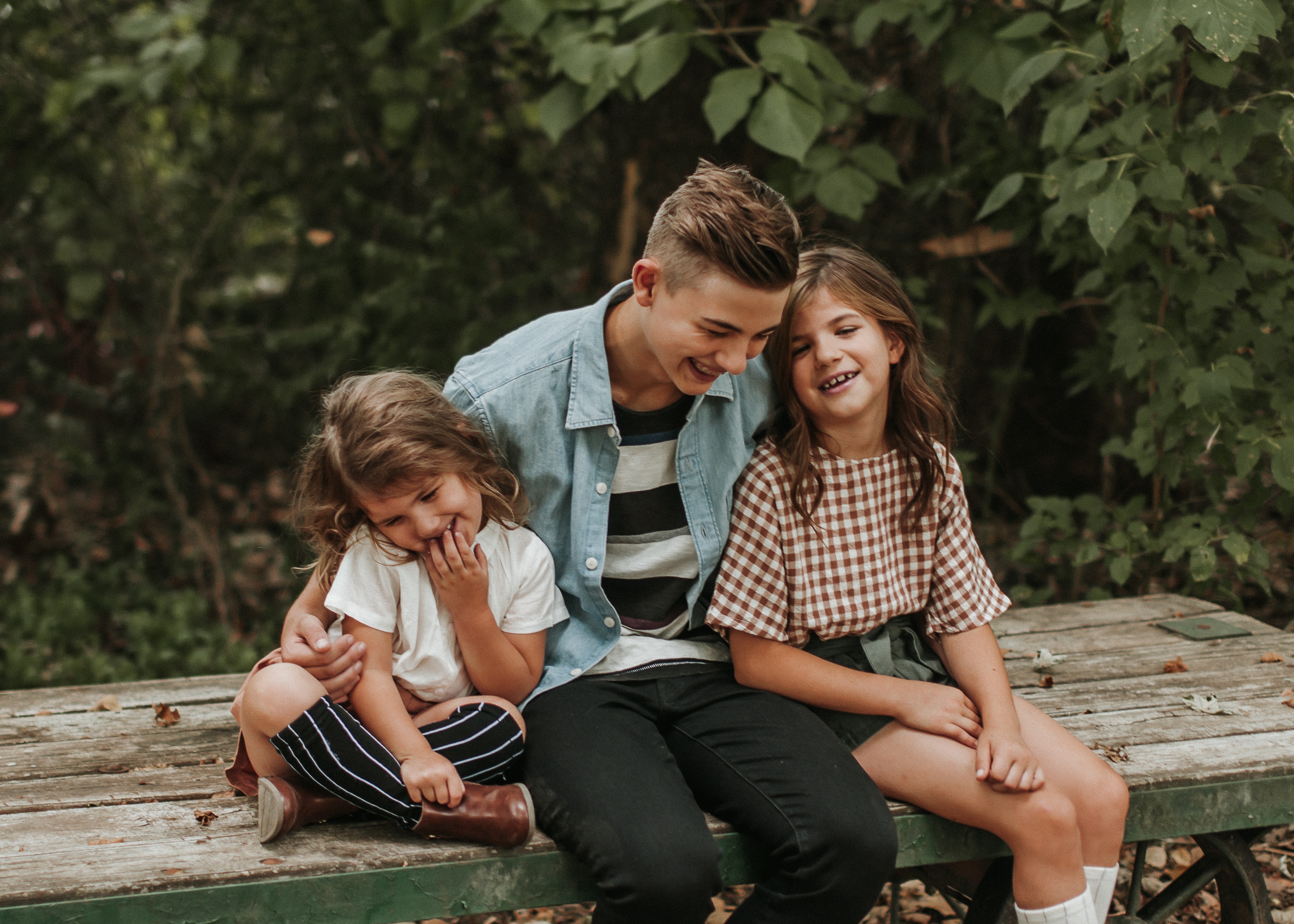 Kinder sitzen gemeinsam auf einer Holzbank